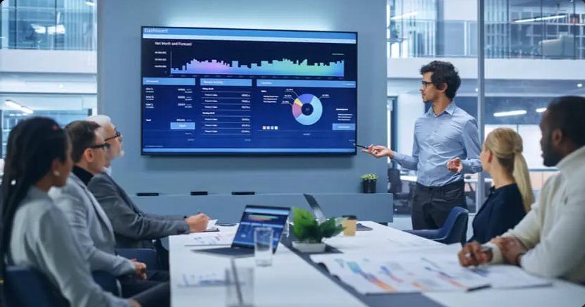 Un consultant présente un tableau de bord d'indicateurs de performance à une équipe en salle de réunion
